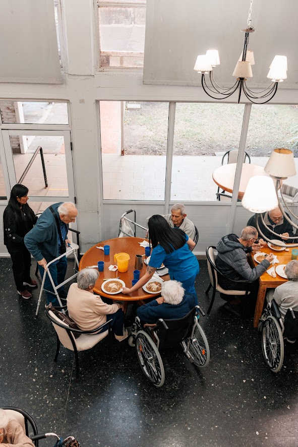 Enfermera sirviendo comida a residente en el comedor principal